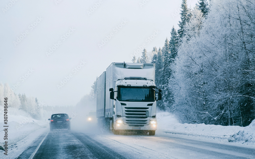 Poster Winter road with snow. Truck in Finland. Lorry car and cold landscape of Lapland. Europe forest. Finnish City highway ride. Roadway and route snowy street trip. Delivery in downhill driveway driving