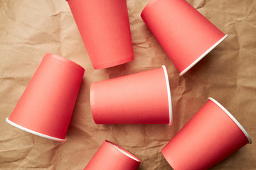 pile of disposable red paper cups on paper background. eco friendly concept. look from above. background backdrop..