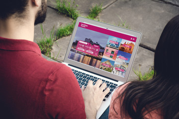 Man with laptop booking a hotel on website