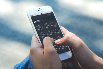Woman holding smartphone with calendar app