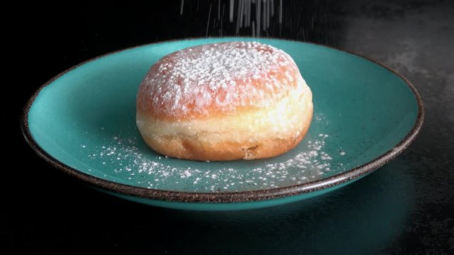 Pfannkuchen (Berliner) werden mit Puderzucker bestreut