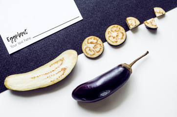 Creative layout from a solid and sliced eggplant on a white background.