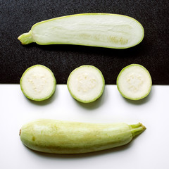 Creative layout of whole and sliced zucchini; laid out in a square form. Seamless pattern. Vegetables isolated on white background. View from above