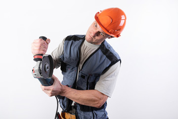 Builder with angle grinder, in a helmet, with a funny expression on his face.