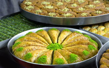 triangular shaped baklava with pistachio in round tray. turkey specific dessert