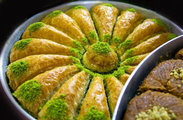 triangular shaped baklava with pistachio in round tray. turkey specific dessert