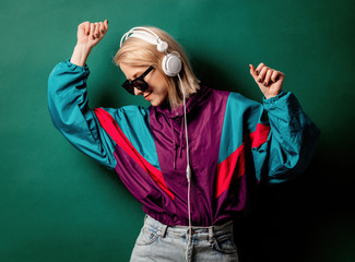 Style woman in sunglasses with headphones on aqua menthe color background