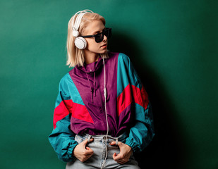 Style woman in sunglasses with headphones on aqua menthe color background