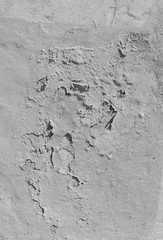 Close-up of a weathered and old concrete wall, paint is peeling off. High resolution abstract full frame textured background in black and white.