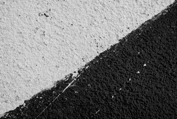 Close-up of a plastered and rough wall painted in white and black. High resolution full frame textured background in black and white.