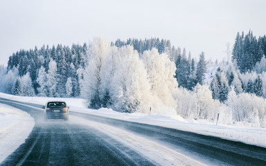 Car on Winter road with snow in Finland. Auto and Cold landscape of Lapland. Automobile on Europe...