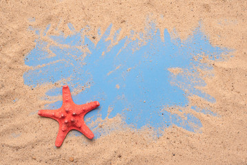 Fototapeta na wymiar Sand beach and red starfish on blue background with copy space. Summer vacation concept. Top view.