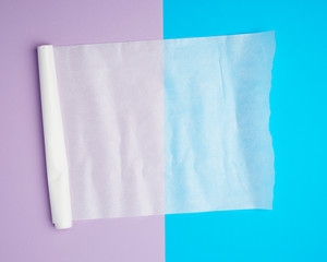 unwound white parchment baking paper on a blue purple background
