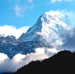 Amazing autumn panorama with mountains covered with snow and forest against the background of blue sky and clouds. Mount Everest, Nepal. - obrazy, fototapety, plakaty