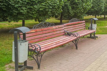 Two old benches with wrought-iron elements and iron urns