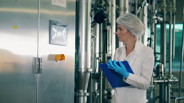 Plant equipment is being managed by a female employee ay a modern food factory.