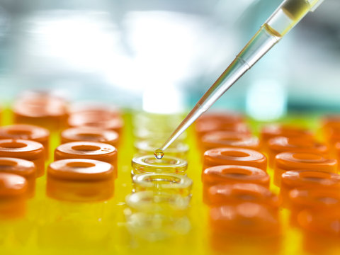 Samples being poured from pipette in vials for analytical testing at laboratory