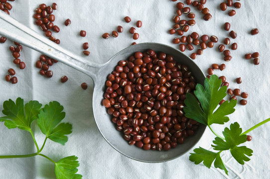 Directly above shot of adzuki beans in ladle on tablecloth