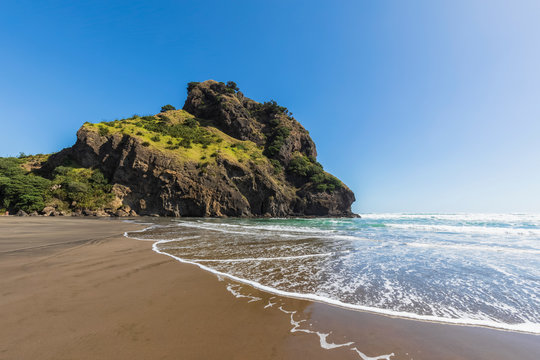 Scenic view of Piha Beach against clear blue sky during sunny day, Auckland, New Zealand