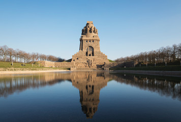 Lake of tears with reflection of V?lkerschlachtdenkmal against clear blue sky, Saxony, Germany