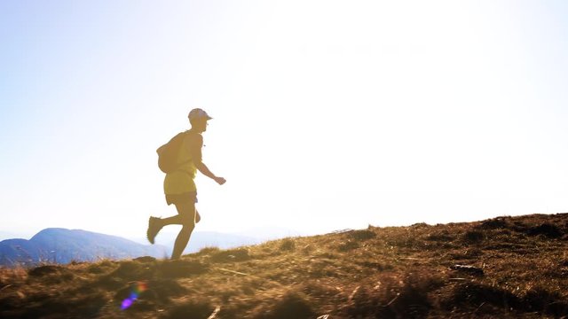 A marathon runner jogging in the hills in slow motion