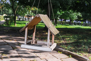bird feeder in the form of a house hanging on a tree in Park