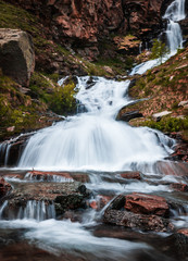 Obraz premium Waterfall in Gran Paradiso Italian alps mountains in Graian Alps in Piedmont, Italy with snow capped peaks.