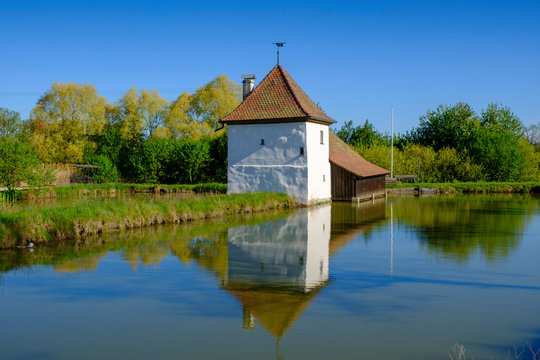 Museum by lake in trees against clear blue sky, Erlangen, Germany