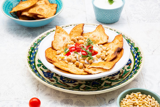 Close-up of Fatteh on plate with mint yoghurt in bowl