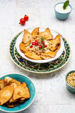 High angle view of Fatteh on plate with mint yoghurt in bowl