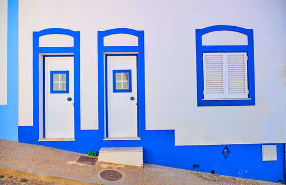 Portugal, Algarve, Arrifana, Pair of entrance doors of clean white and blue house