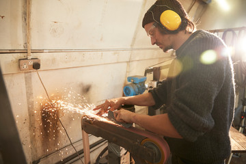Man grinding a blade in a workshop