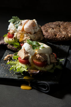 Close-up of open faced sandwich on table against black background