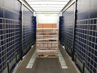 Cardboard boxes loaded on a tented truck for transportation