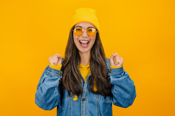 Asian stylish gitl with joyful expression against yellow background
