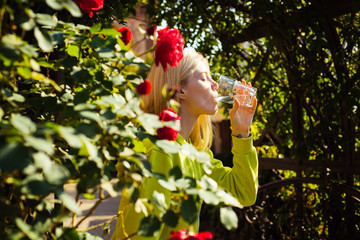 Portrait in profile of a young attractive woman thirsty drinking a glass of water, closing her...