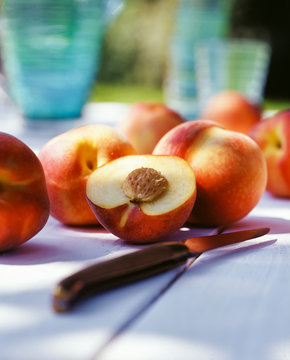 Close-up of fresh peaches with knife on table