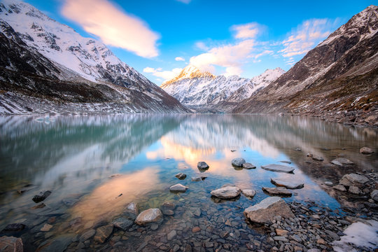 New Zealand, South Island, Rocky shore of Hooker Lake with Mount Cook and Hooker Glacier in background