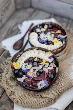 High angle view of ice cream garnished with fruits and flowers served in bowls on table