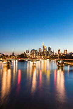 Illuminated Ignatz Bubis Bridge over River Main against blue sky during sunset, Frankfurt, Germany