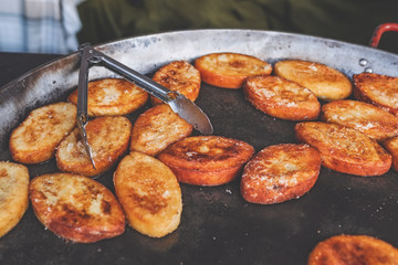 Fried potato patties on big pan. Street food concept. Close-up, toned