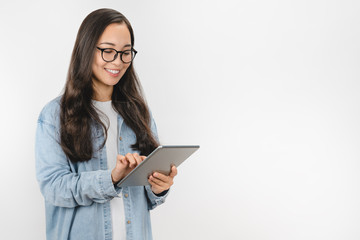 Smiling young woman using tablet computer isolated on white background