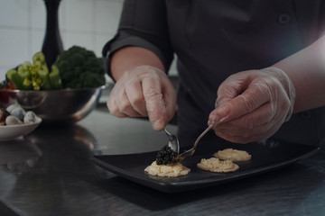 cook makes sandwiches with black caviar.