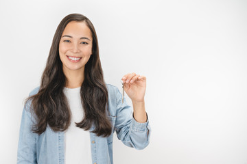Portrait of cheerful woman in casual showing keys isolated over white background