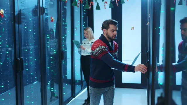 Professional data center team of IT engineers inspecting a holidat decorated server cabinet, using web technology cloud computing on database. Christmas holidays in cyberspace.