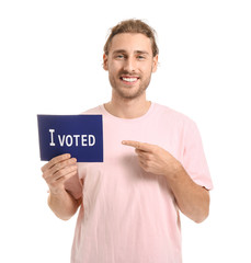 Young man holding paper with text I VOTED on white background