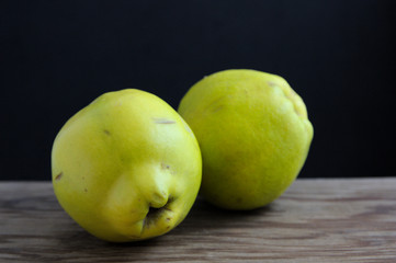 Quinces on a wooden board with dark background