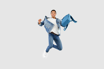 Fototapeta Jumping African-American teenager boy with backpack on white background obraz