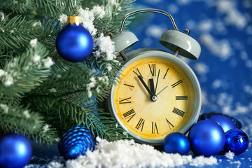 Fototapeta na wymiar Alarm clock, fir tree and snow on color background. Christmas countdown concept