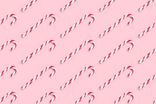 Seamless background pattern of christmas candy cane isolated on pink background